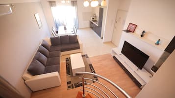 Comfort-Apartment, eingeschränkter Meerblick | Wohnbereich | 100-cm-Smart-TV mit Satellitenempfang