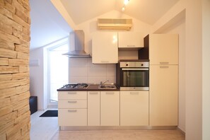 Apartamento conforto, vista parcial para o mar | Cozinha privada | Geladeira grande, micro-ondas, fogão, cooktop