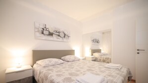 A neatly arranged bedroom with a large bed, two bedside tables, and a wall-mounted mirror. - Apartment Skroce (Zaton)