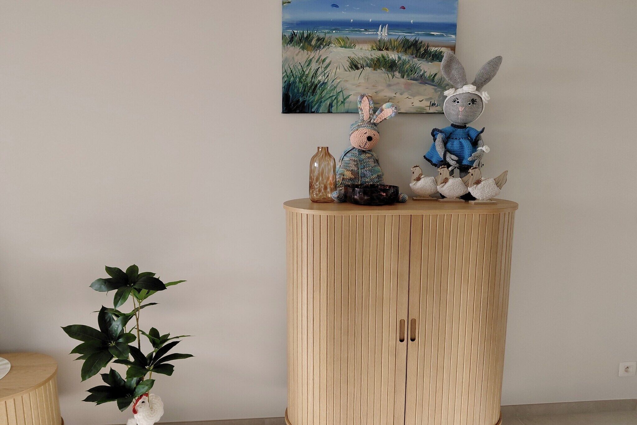 Puisesta kaapista, jonka yläpuolella on taulu, jossa on kuvattuna rantamaisema.