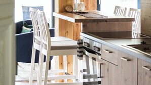Een moderne keuken met houten kastjes, een centraal eiland en barstoelen.
