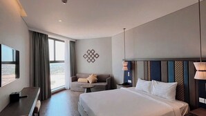 Una moderna camera d'albergo con un letto grande, una scrivania e un divano.