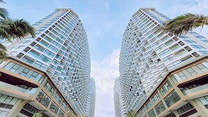 Un edificio moderno di grandi dimensioni, con un design architettonico simmetrico, numerosi infissi e balconi.