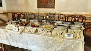 Een buffettafel met aangeduide gerechten, waaronder brood, fruit en havermout.