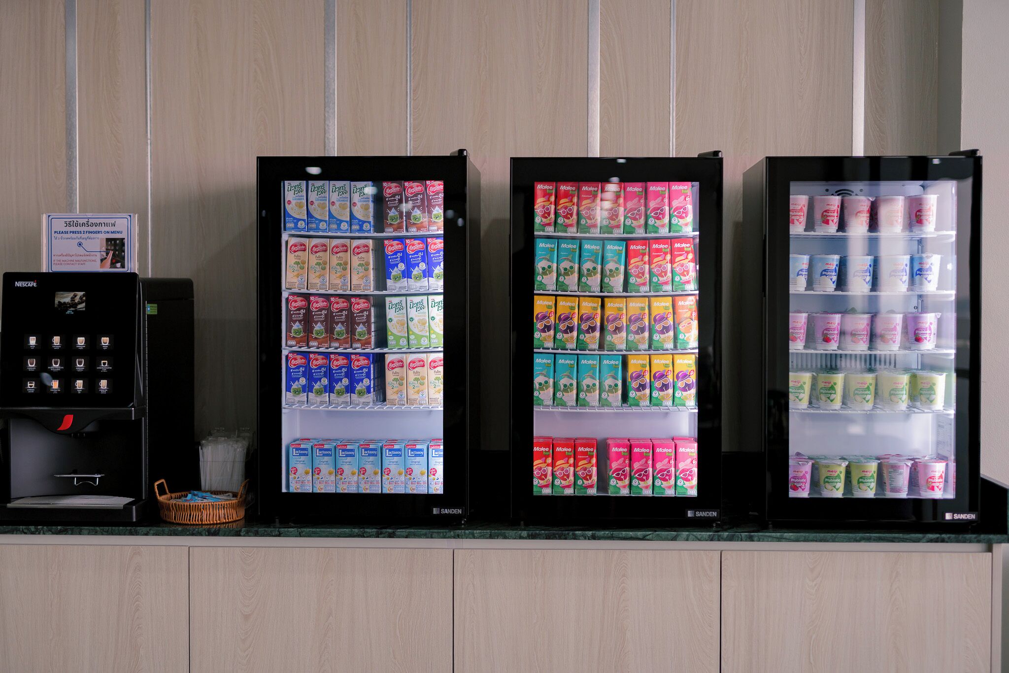 Three beverage vending machines with various drink options.