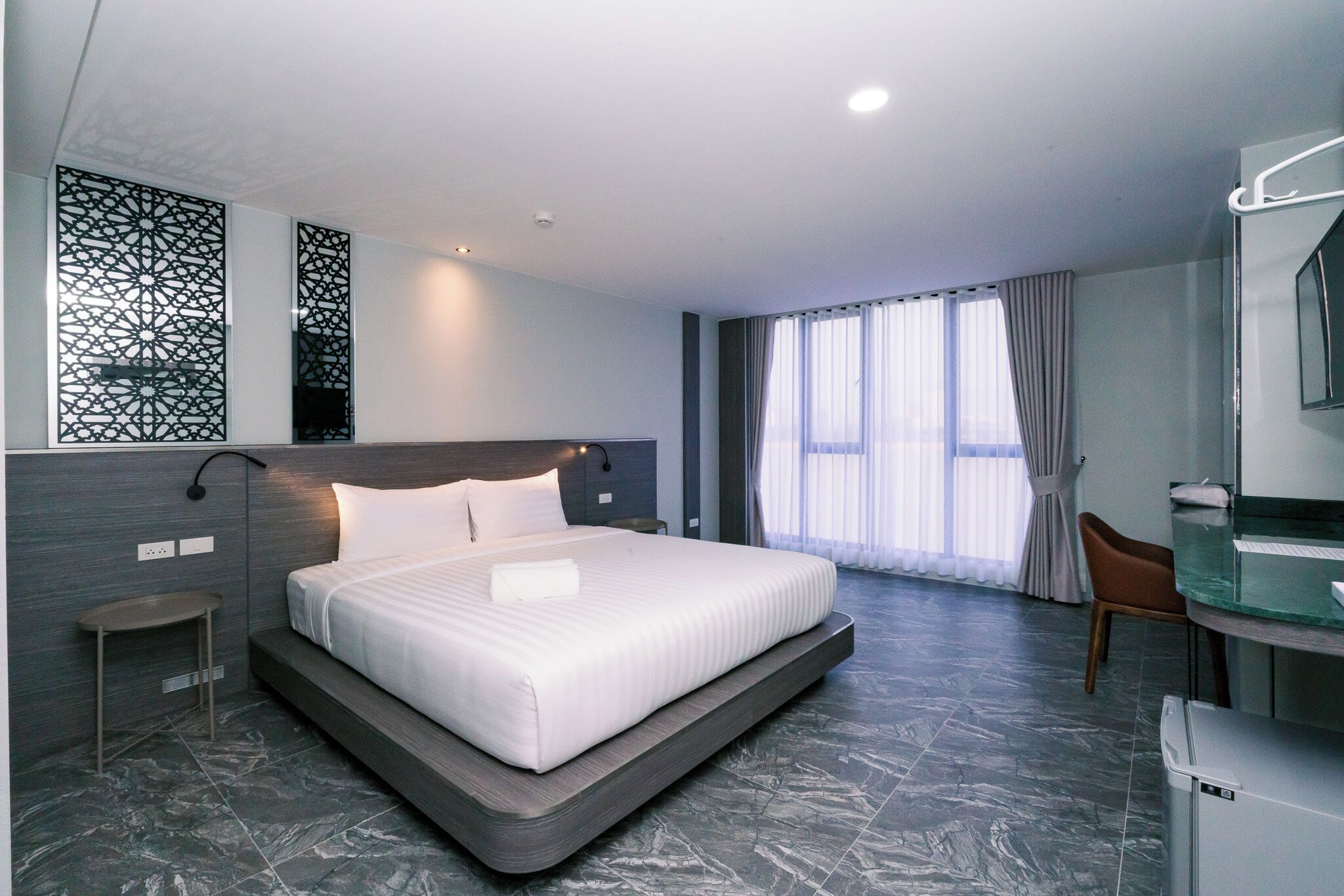 Une chambre d’hôtel moderne avec un grand lit, un bureau et une salle de bain.