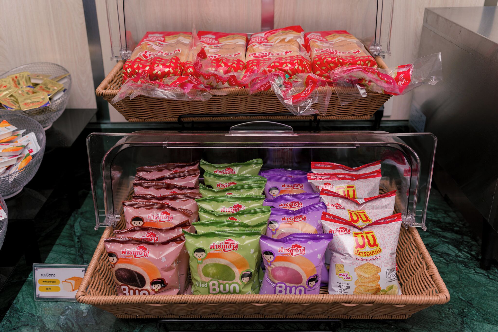 Une variété d’aliments emballés, notamment des pains et des en-cas, sont présentés sur un comptoir.