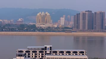 Un bâtiment moderne à plusieurs étages, doté d’un espace de stationnement et bordé, à l’arrière-plan, par un plan d’eau.