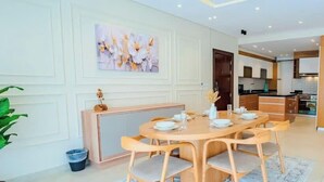 A modern living room with a dining area, a kitchen in the background, and a hallway leading to other rooms. - Luxury 3BR • Lakeview Residence • Premium Stay (القاهرة)