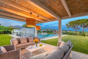 A covered outdoor seating area with a pool, lounge chairs, and a view of the landscape. - 9 Bedrooms Luxury Villa with Pool in Lucca (Montecarlo)