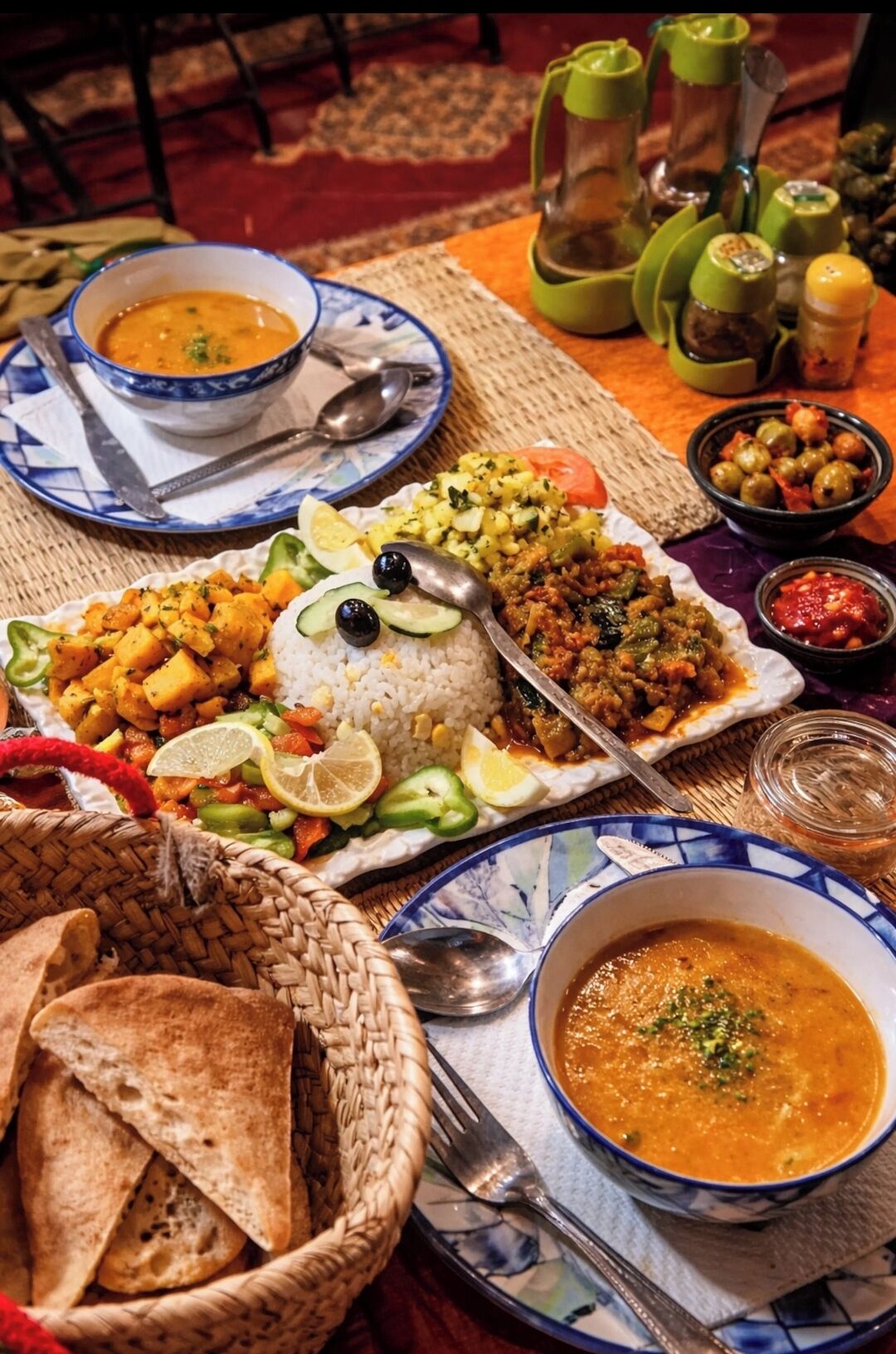 Een tafel met diverse gerechten, zoals rijst, groenten en een kom soep.