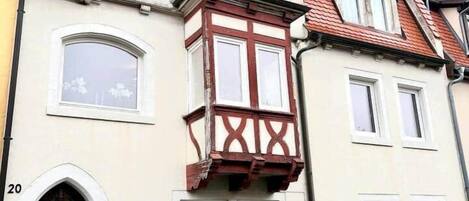 A building with a bay window, a wooden door, and a number '20' on the wall.