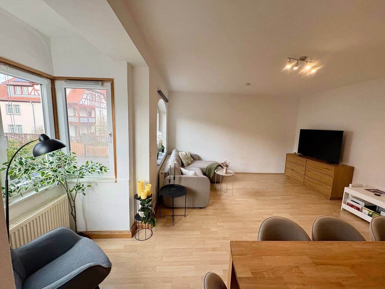Una sala de estar moderna con un sofá, una mesa de comedor y un televisor.