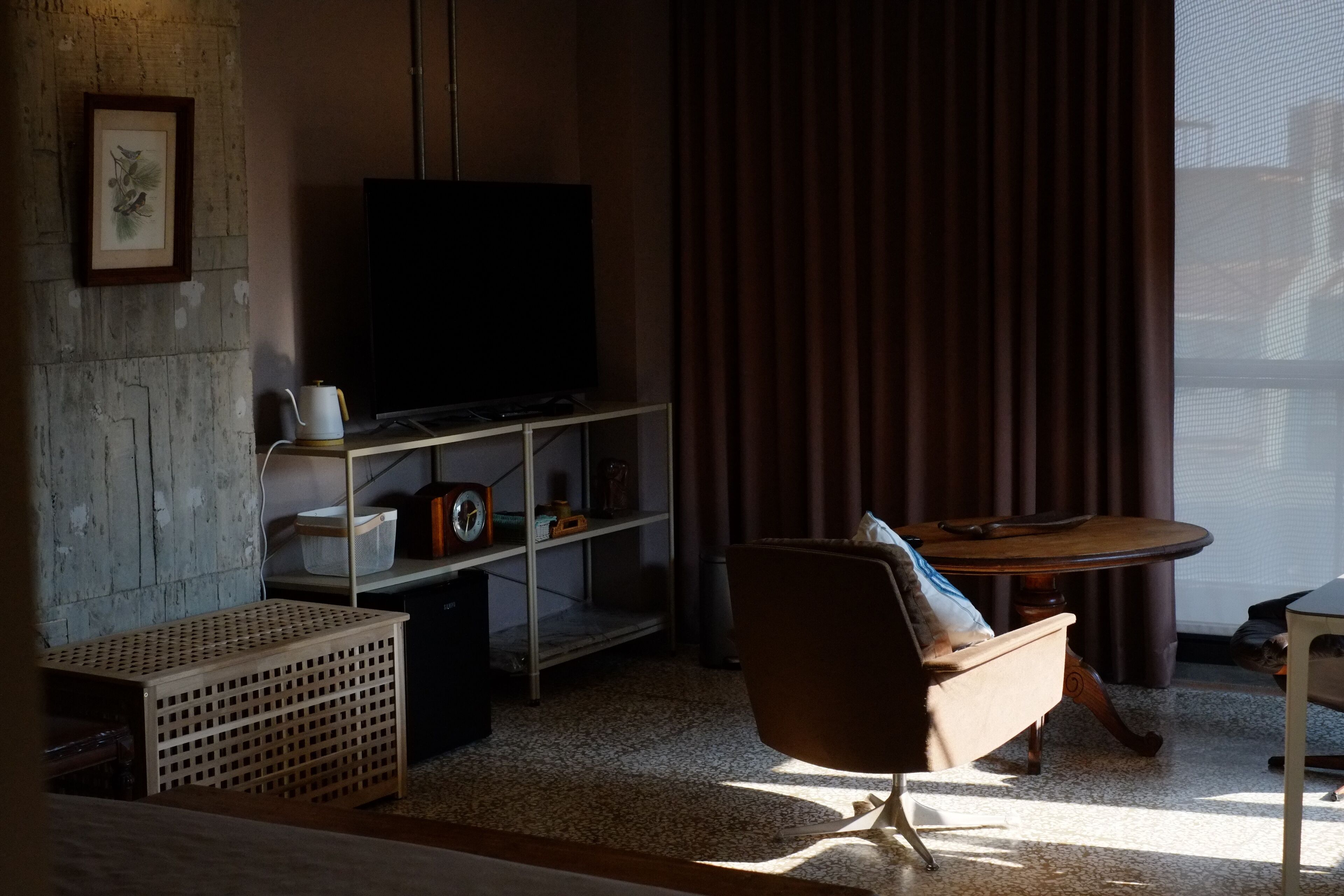 A living room with a television, a sofa, a coffee table, and a bookshelf.
