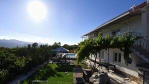 Una villa con piscina, un espacio exterior cubierto y vistas a las montañas.