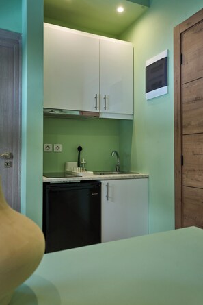A compact kitchen with a built-in dishwasher, a sink, and cabinets. - Harmony 89 (Palaio Faliro)