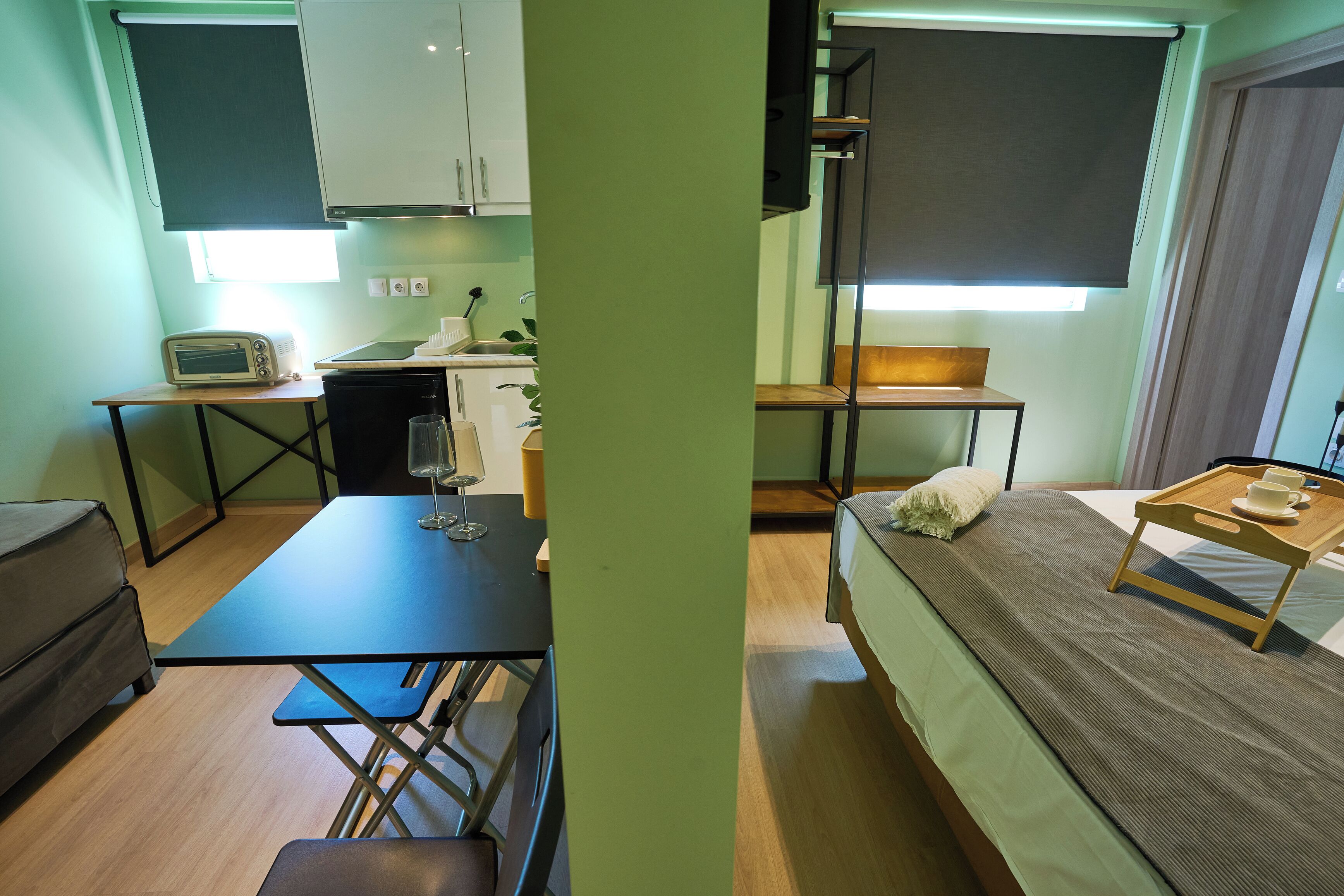 Habitación compacta con kitchenette, comedor y cama.