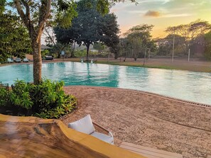 A swimming pool with lounge chairs and a wooden deck. - Vipingo Ridge Swahili Villa (Vipingo)