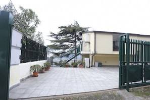 A gated courtyard with potted plants, a staircase, and a building with a beige exterior. - Elegant attic apartment, recently renovated with high-quality finishes, comfortably accommodates 4 people in 150 square meters, with two double bedrooms and two bathrooms. Located in a quiet hillside neighborhood of Salerno, it features a small terrace w (Salerno)