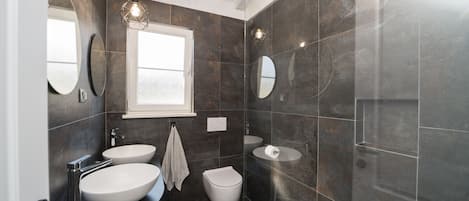 Une salle de bain moderne avec deux lavabos, des toilettes et une douche.