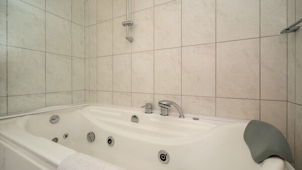 Une salle de bain moderne avec une baignoire sur pieds, une douchette et un porte-serviettes.