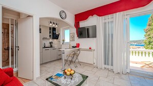 Ett modernt kök med matplats, TV och utsikt över havet.