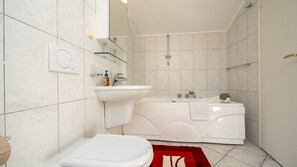 Ein Badezimmer mit Toilette, Waschbecken und Badewanne.
