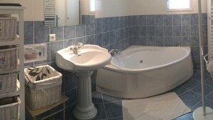 A bathroom with a pedestal sink, a freestanding bathtub, and a large mirror.