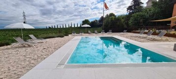 Una piscina al aire libre de temporada, sombrillas