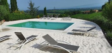 Una piscina al aire libre de temporada, sombrillas