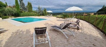 Una piscina al aire libre de temporada, sombrillas