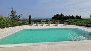 A rectangular swimming pool with a clear blue water, surrounded by a white sandy area with lounge chairs. - Corte Belvedere (Sommacampagna)