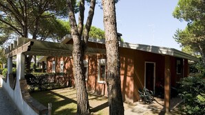 Un bâtiment doté d’un patio couvert, d’une porte et d’un petit espace salon avec des chaises.