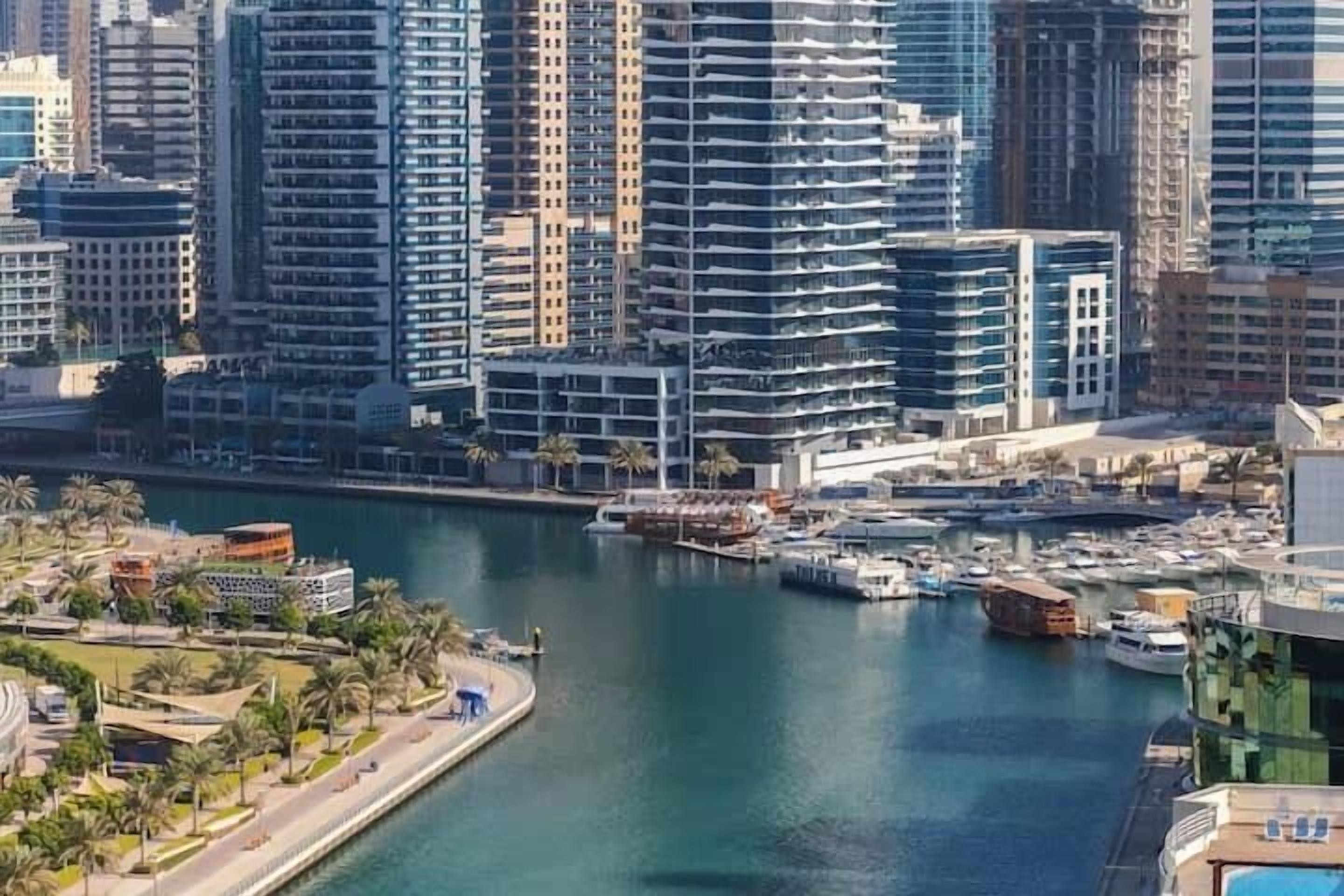 A high-rise building with a marina in the foreground.