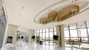 A spacious lobby with a high ceiling, large windows, and modern furniture. - Vogue | 52 | 42 Marina near Ain Dubai | JBR Beach (Dubai)