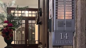 Ein Hotel Eingang mit einer Nummer 14, einem Topf mit Pflanze und einem gemusterten Boden.