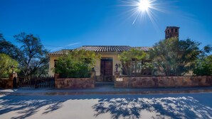 A two-story building with a tiled roof, a wooden door, and a bell tower. - Beautiful House with Stunning Views (Calonge)