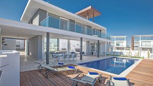 A modern hotel with a rooftop pool, outdoor seating, and a spacious balcony area. - 5 & 6 OP Villas Fig Tree Bay Protaras Bedrooms 8, Bathrooms 6, Sleeps 20 (Protaras)