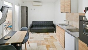 Une cuisine compacte avec un canapé, une table à manger et des chaises.