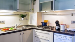 A modern kitchen with a built-in dishwasher, a stove, and a coffee maker. - Cadorna's Nest - Cozy and Central (Milano)