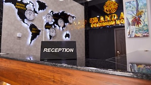 A reception desk with a world map and clocks, a sign for 'GRAND A PREMIUM HOTEL', and a reception area. - Grand Art Premium Hotel (Tashkent)