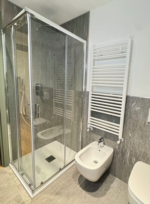 Chuveiro, secador de cabelo, bidê, toalhas de banho