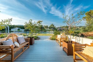 A wooden deck with outdoor seating, a pool, and a view of the surrounding landscape. - Corte Benedetto in Montecarlo (Capannori)