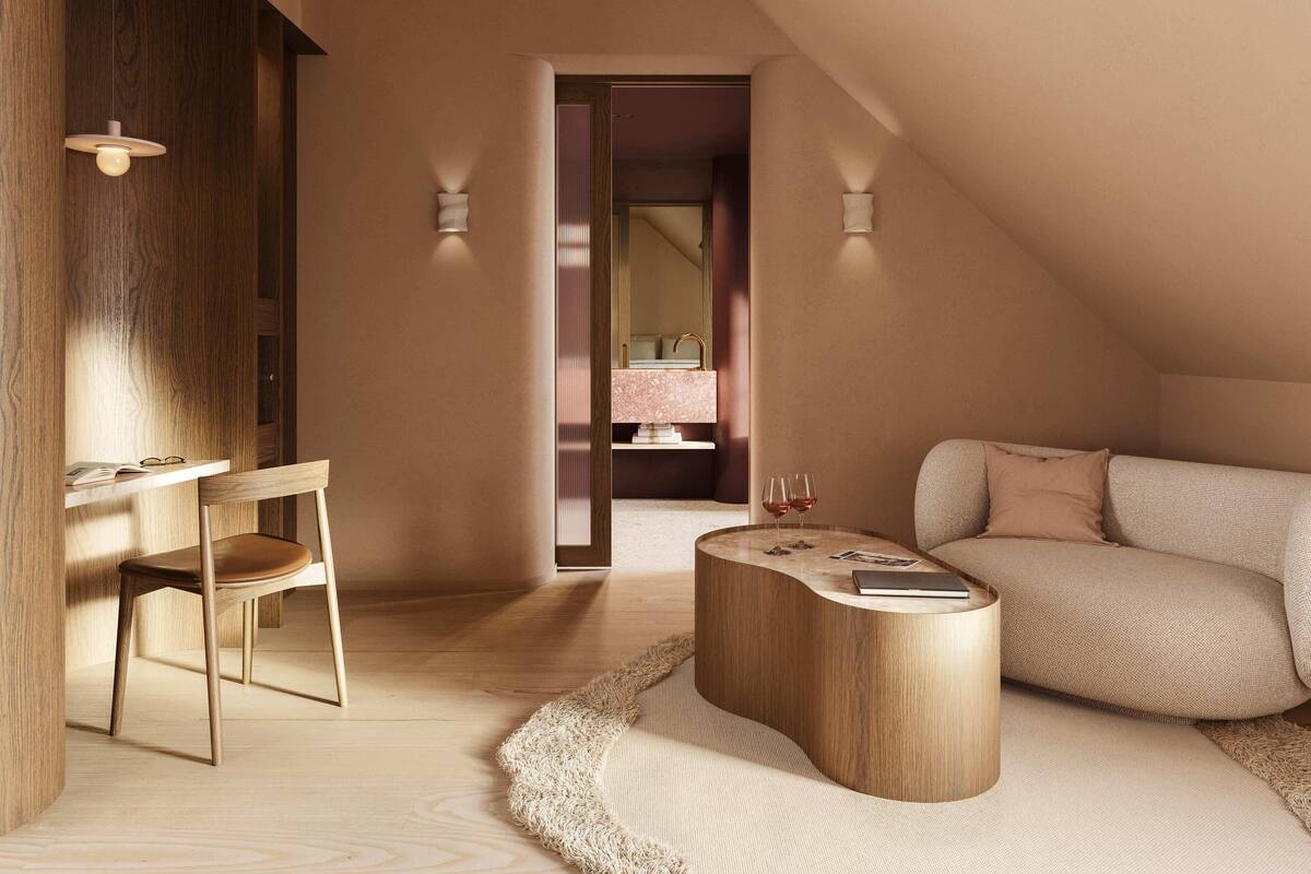 A modern, well-lit room with a wooden desk, a comfortable sofa, and a curved coffee table.