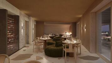 Un espace repas moderne avec des tables rondes, des sièges recouverts d’un tissu vert et un meuble à vin.