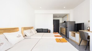 A hotel room with two beds, a kitchenette, a TV, and a desk. - SKYCONDO Phnom Penh (Phnom Penh)