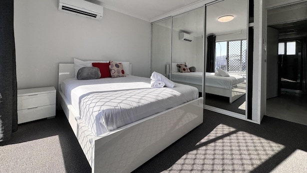 A modern bedroom with a large bed, a bedside table, a wardrobe, and a ceiling light. - Great Location Close to the City and Strand - Great Location Close to the City and Strand (North Ward)