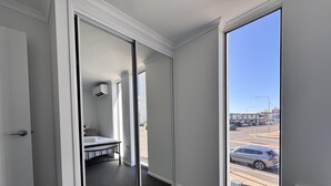 A hotel room with a large sliding glass door leading to a balcony with a city view. - Great Location Close to the City and Strand - Great Location Close to the City and Strand (North Ward)