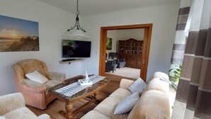 Un soggiorno con un divano, un tavolino, una televisione e un quadro appeso al muro.