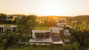 Et moderne hus med fladt tag, swimmingpool og velplejet have.